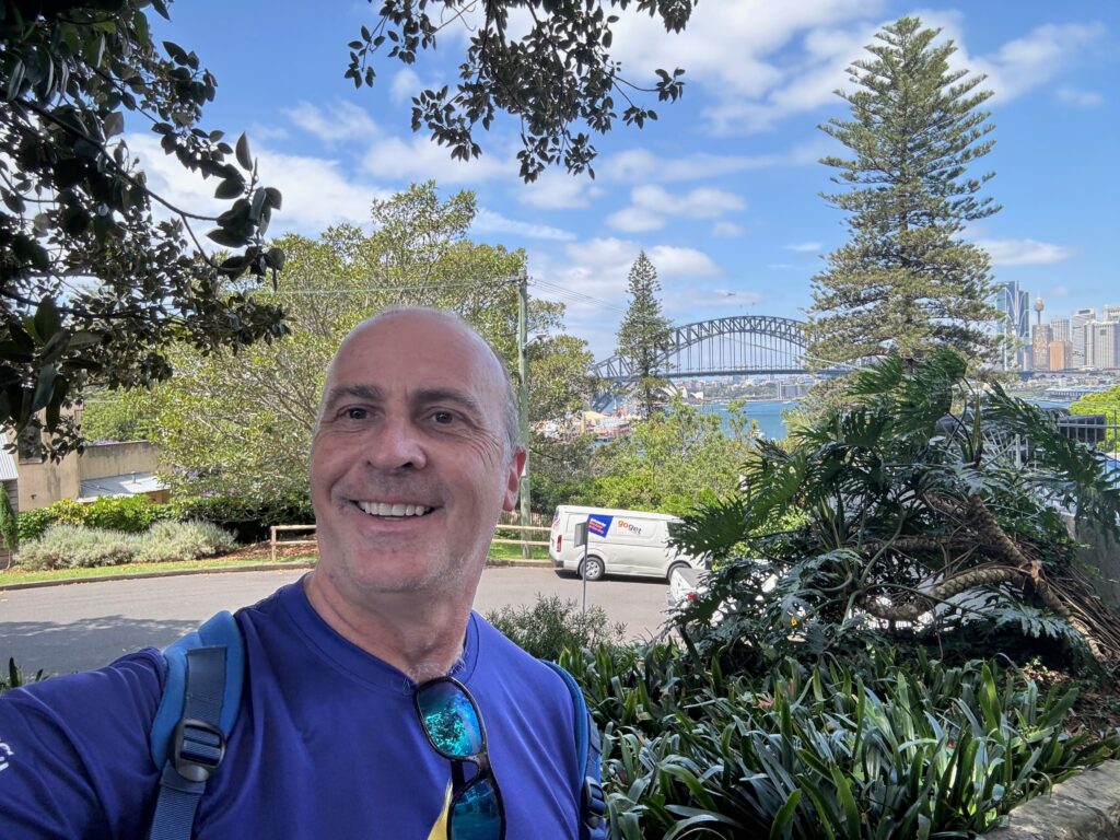 a man taking a selfie in front of a bridge