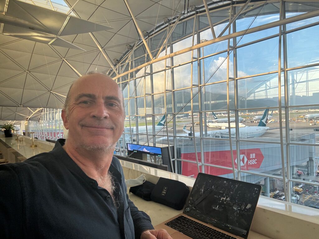 a man sitting in a room with a laptop