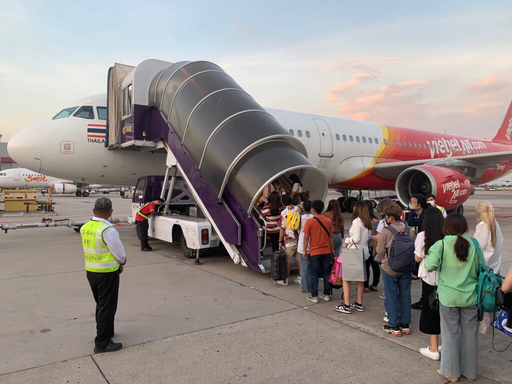 a group of people standing next to an airplane