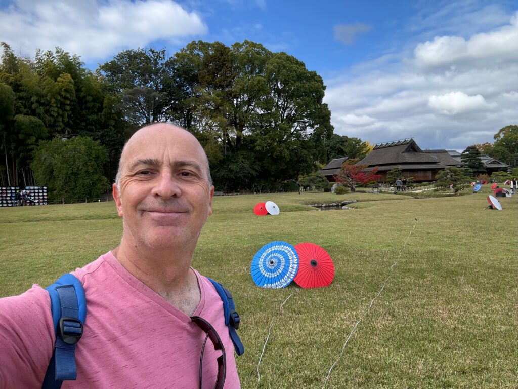 a man standing in a field with two umbrellas