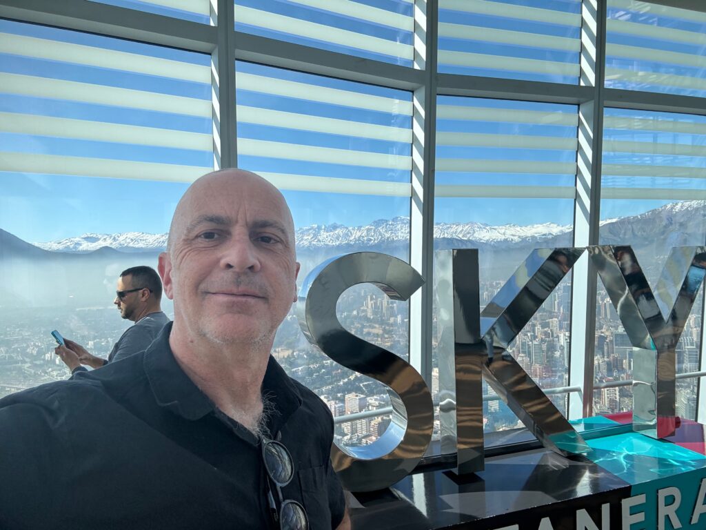 a man standing in front of a large window with a city in the background