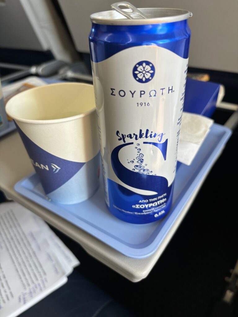 a blue and white beverage can and a cup on a tray