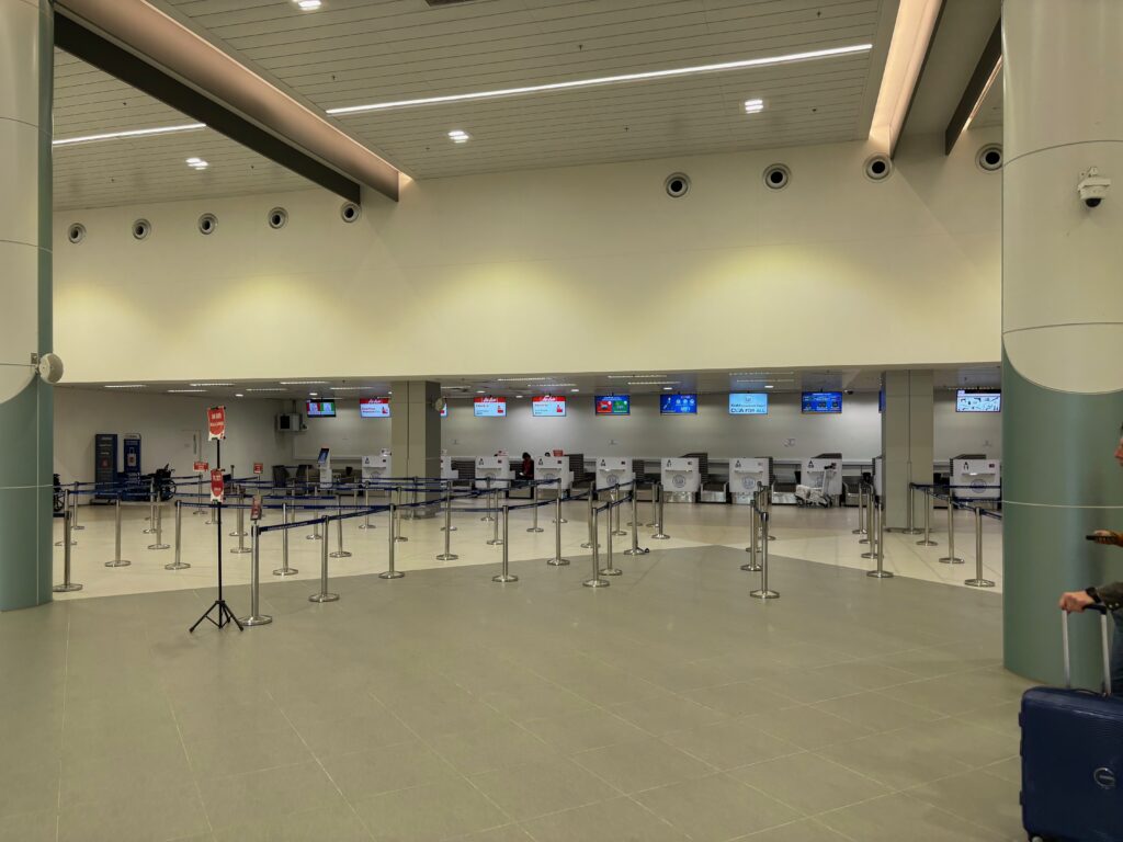 a large airport terminal with a few counters and a row of tables