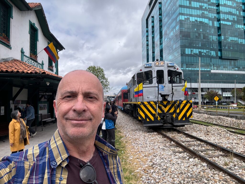 a man taking a selfie in front of a train