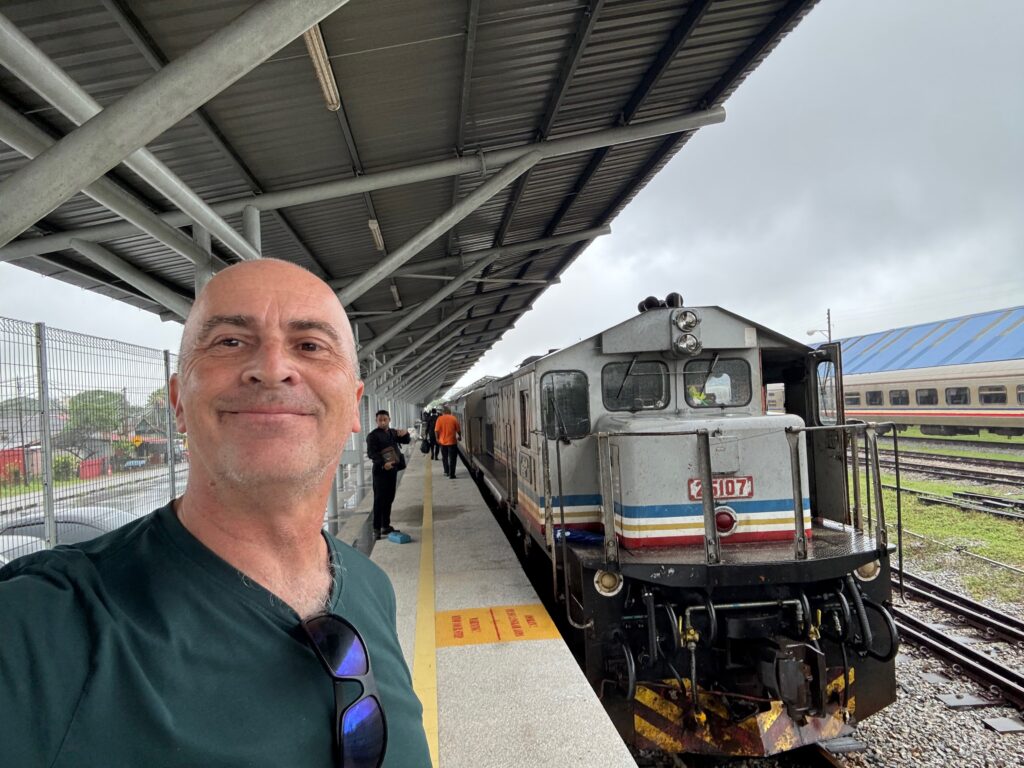 a man taking a selfie at a train station