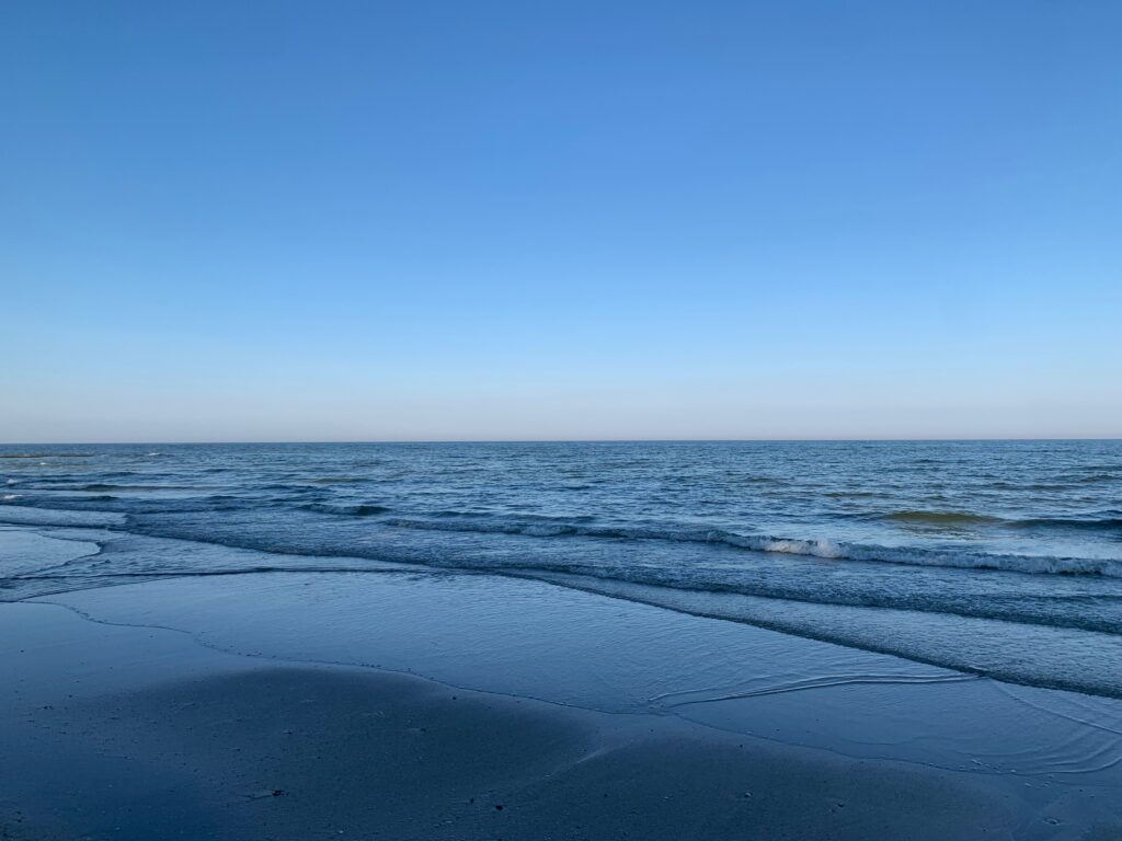 a beach with waves and blue sky