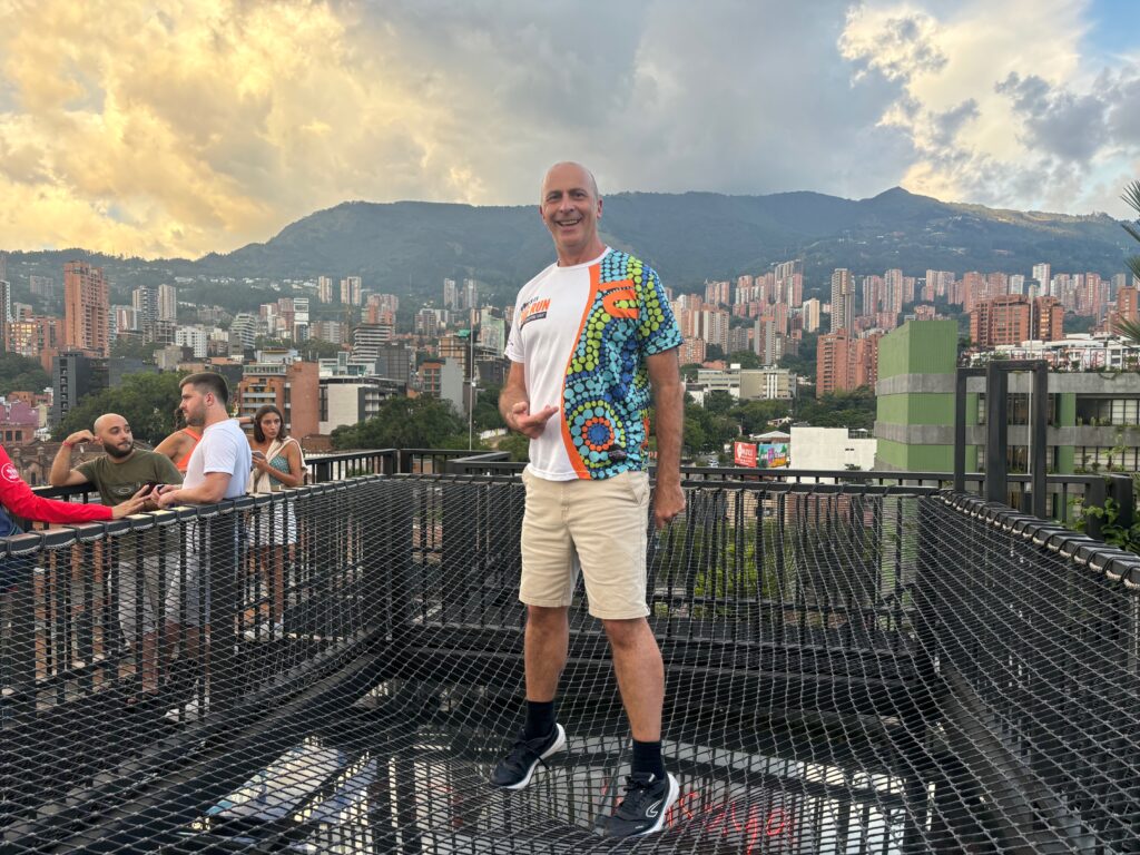 a man standing on a balcony with a city in the background