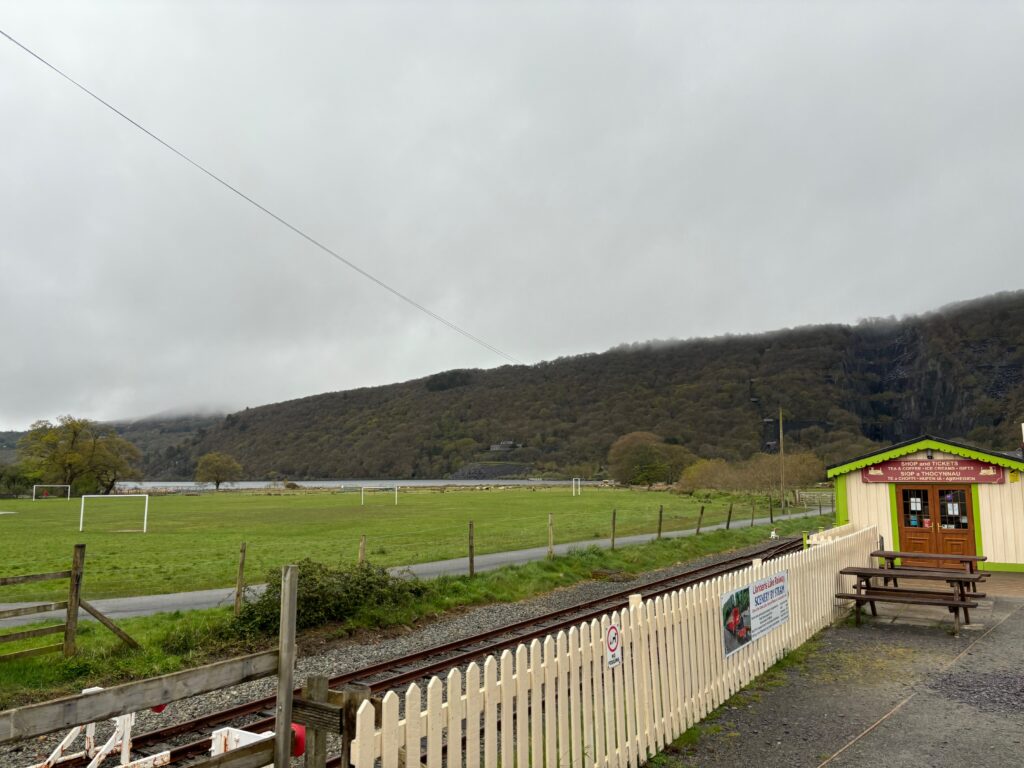 a train tracks next to a field