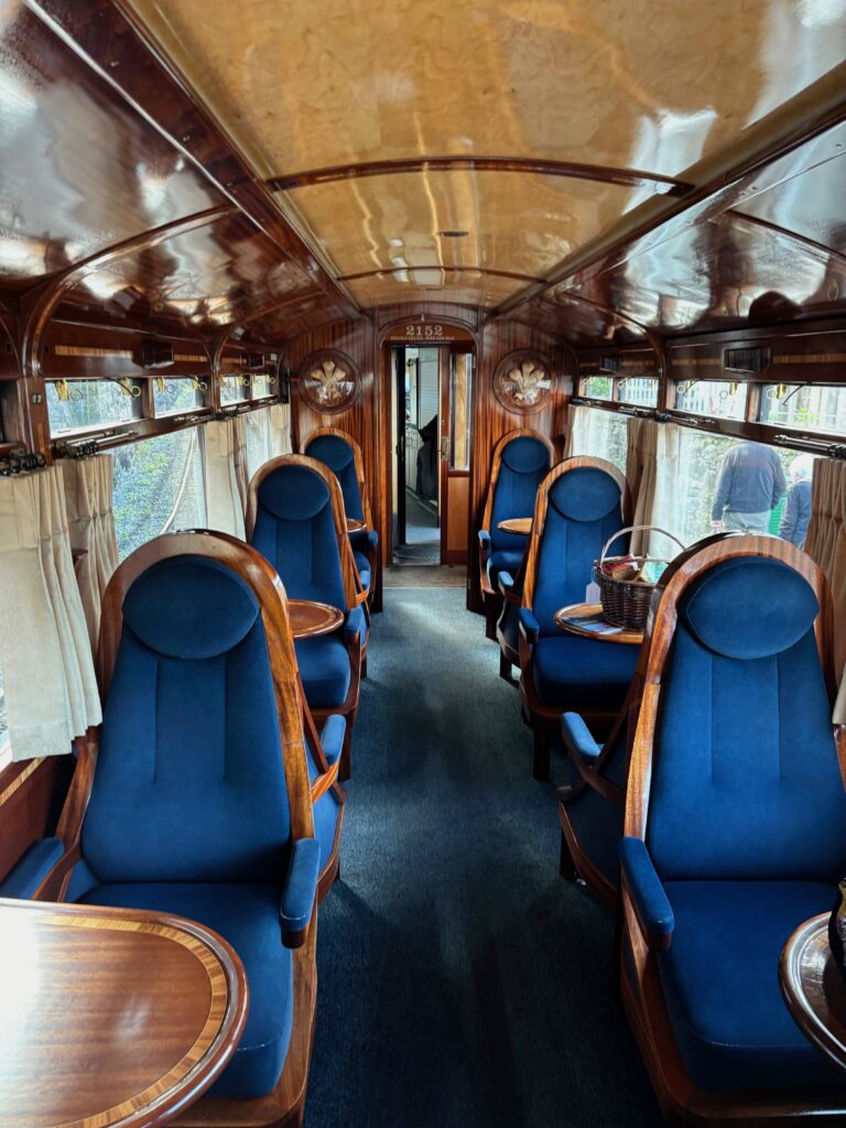 a interior of a train with blue chairs and tables