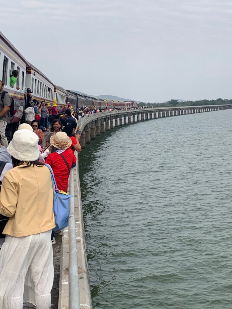 a group of people standing on a bridge over water