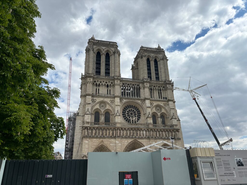 a large building with towers and a fence with Notre Dame de Paris in the background