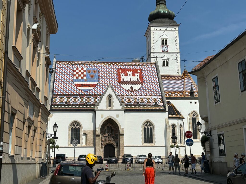 a woman in a yellow helmet walking down a street with a church