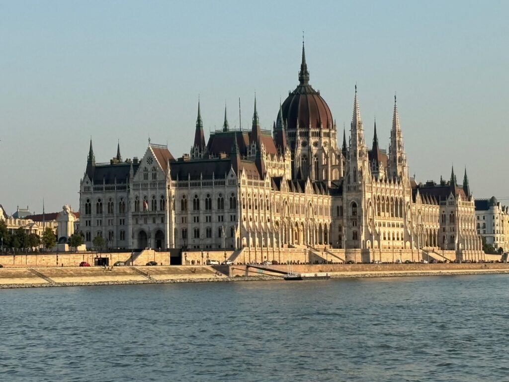 a large building with many spires and a domed roof with Hungarian Parliament Building in the background