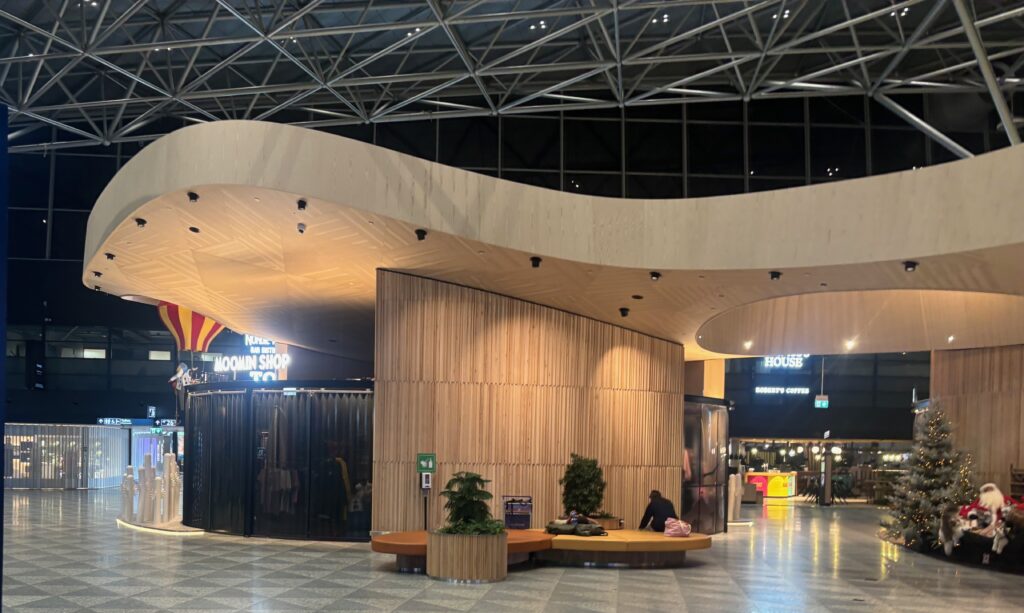 a building with a curved wall and a person sitting on a bench