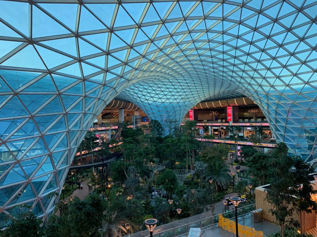 a glass dome with trees and buildings in the background