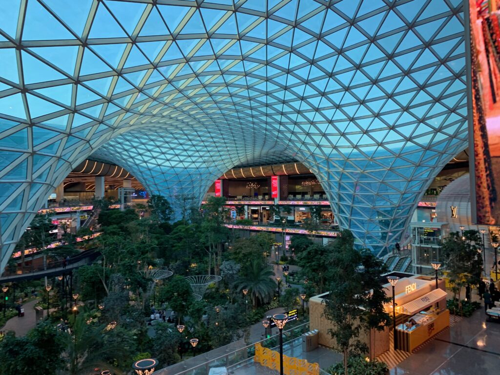 a glass roof with trees and people inside