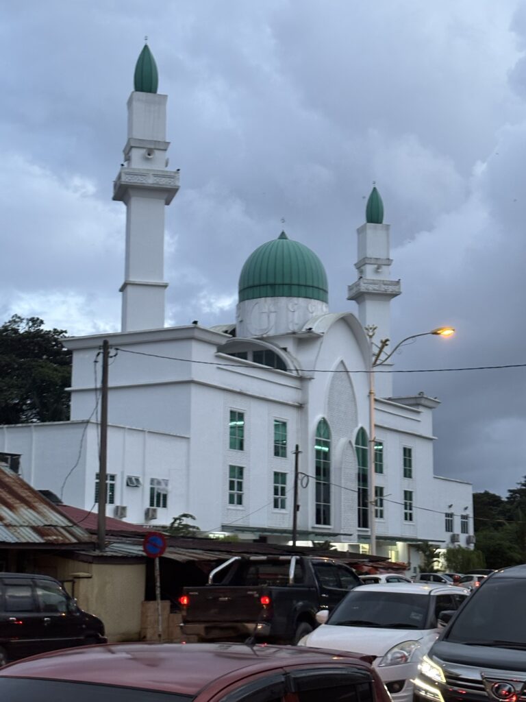 a white building with a green dome and towers