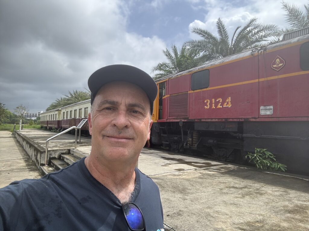 a man taking a selfie in front of a train