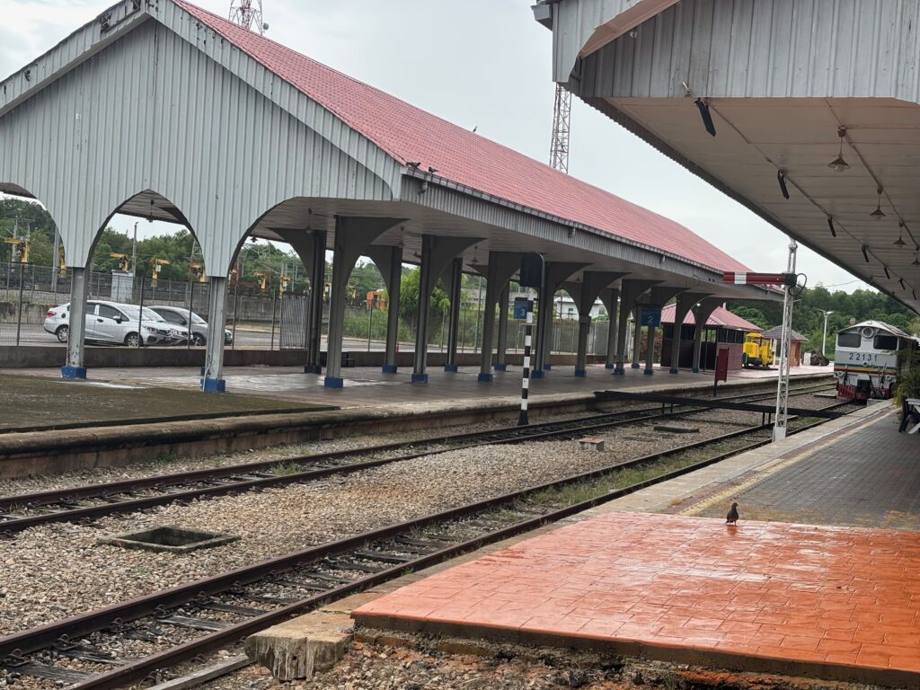 a train station with a roof over the tracks