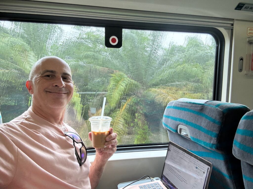 a man sitting in a bus holding a cup of coffee