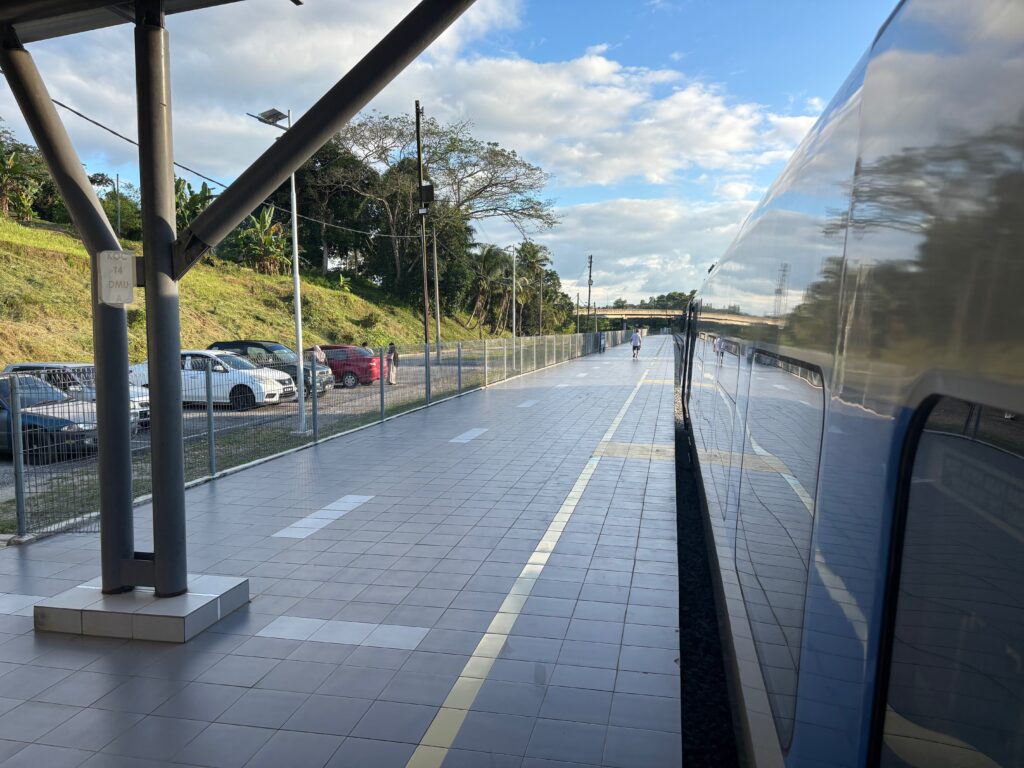 a walkway with a metal wall and a fence