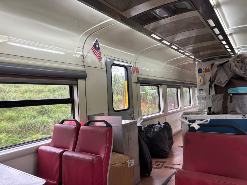 inside a train with red seats and a flag