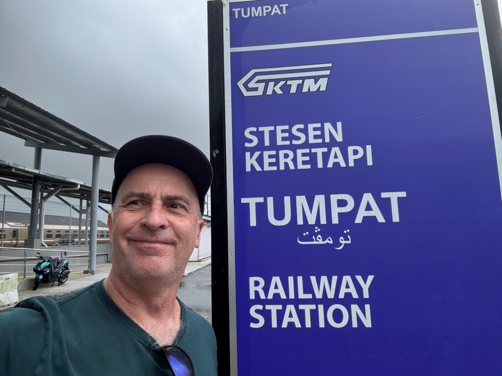 a man standing next to a sign