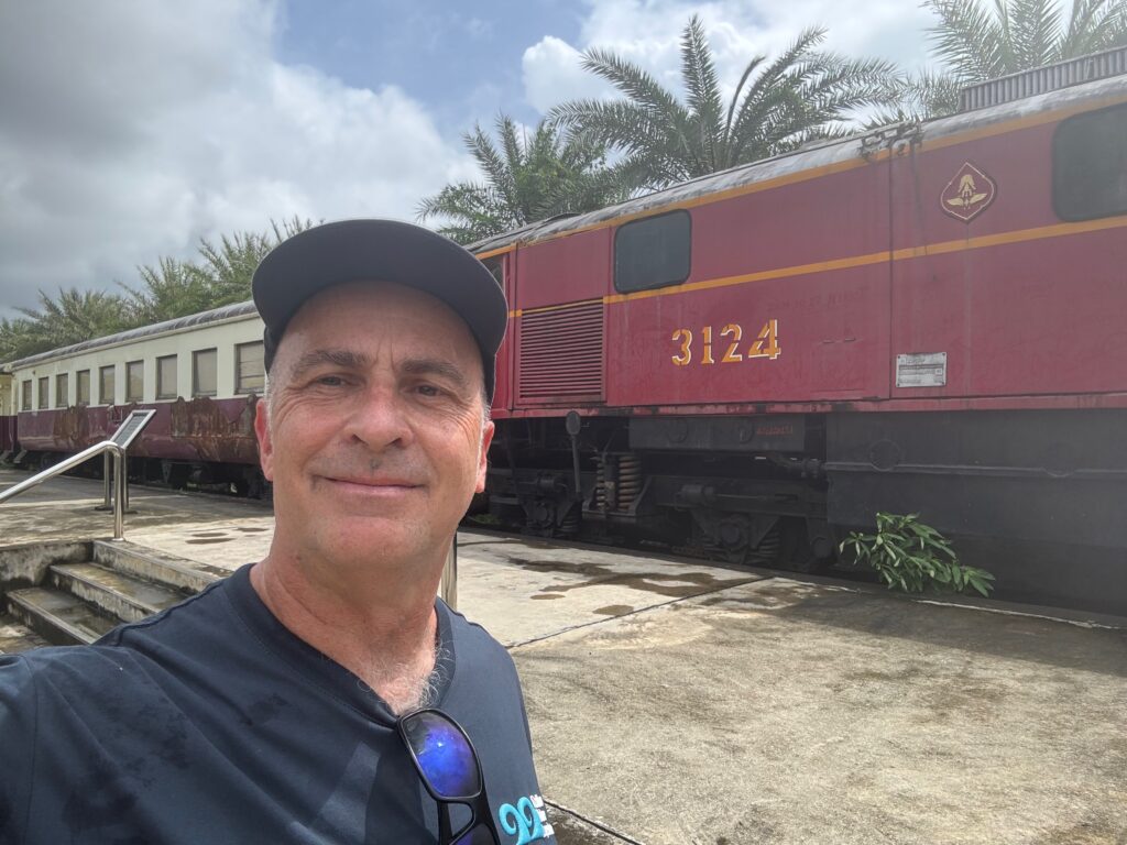 a man taking a selfie in front of a train