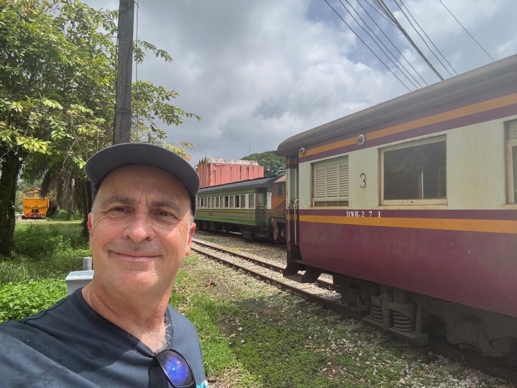 a man taking a selfie in front of a train