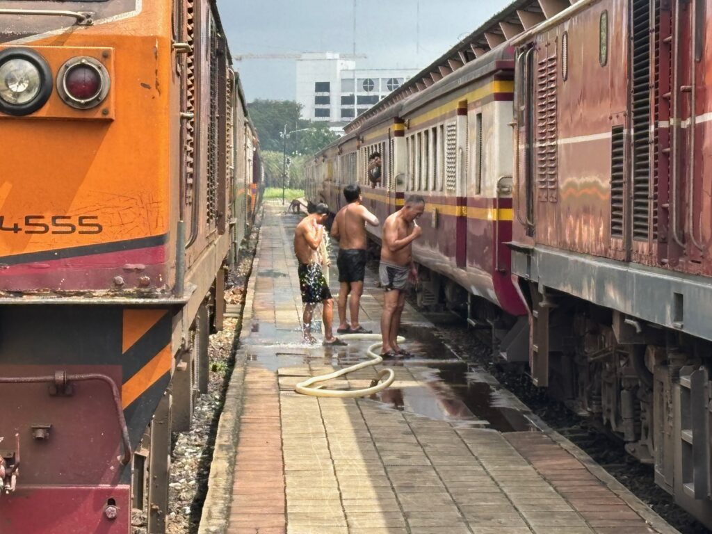 a group of men standing next to a train