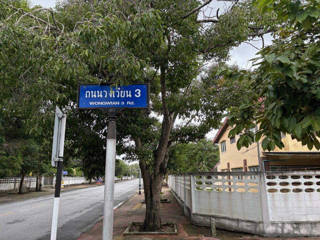 a street sign on a pole next to a tree