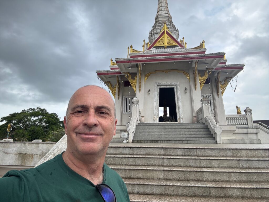 a man taking a selfie in front of a building