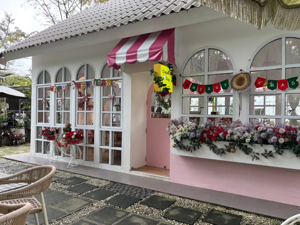 a small white house with pink walls and windows