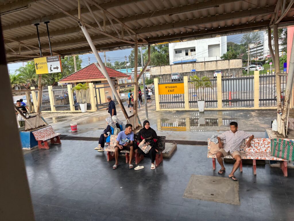 people sitting on benches under a roof