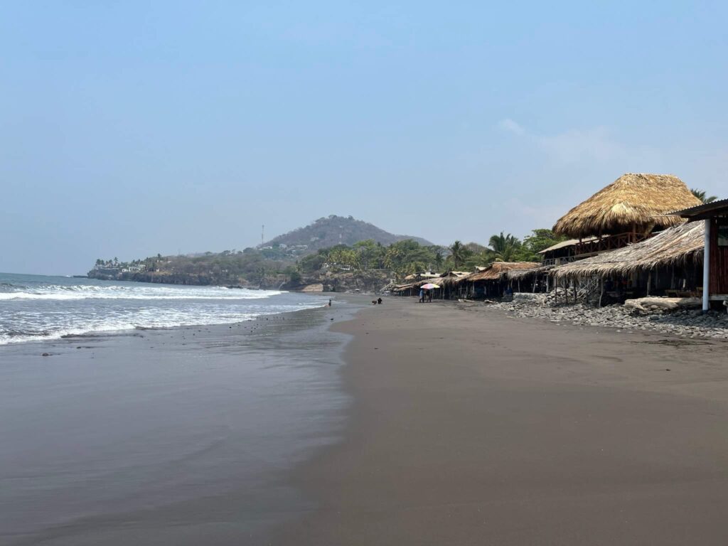 a beach with huts and a body of water