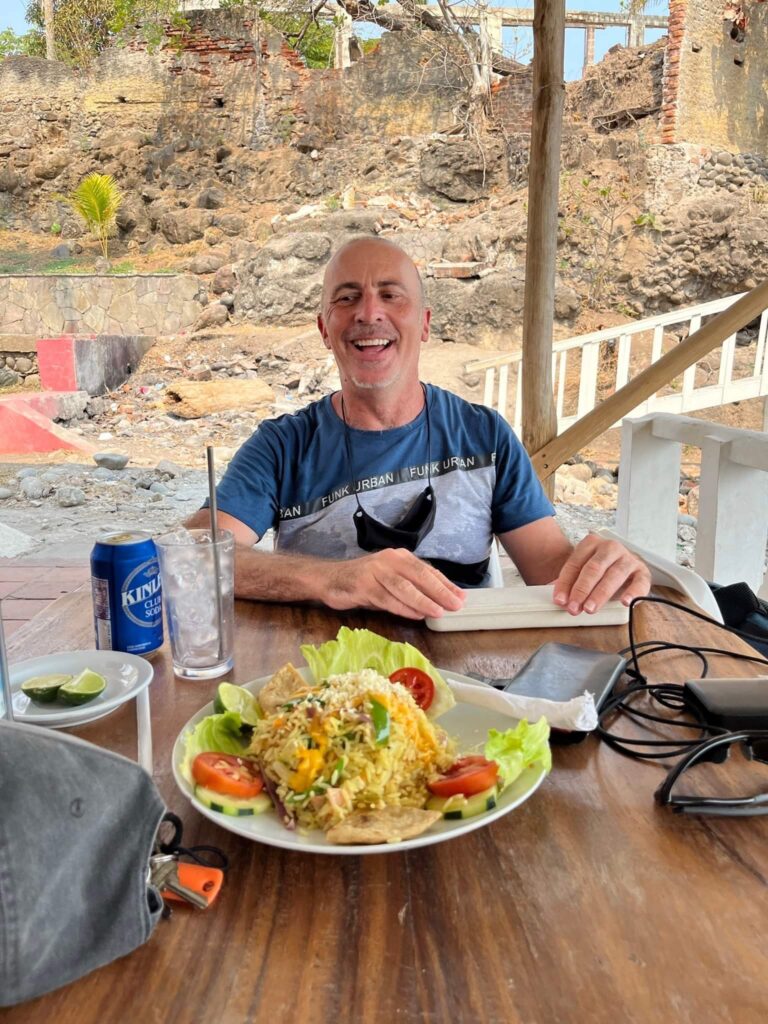 a man sitting at a table with food on it