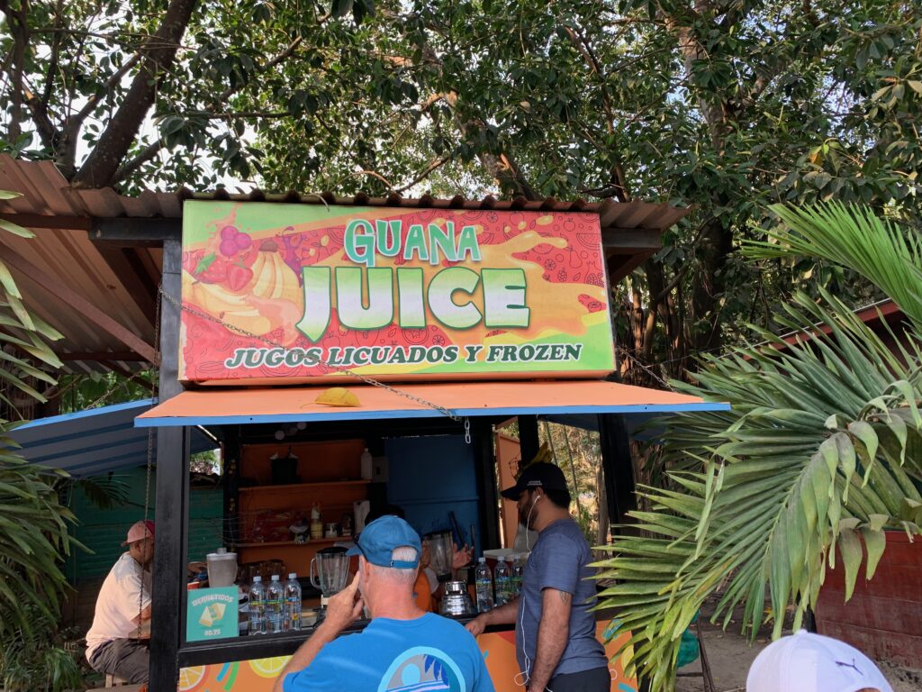 a group of people standing outside a juice stand