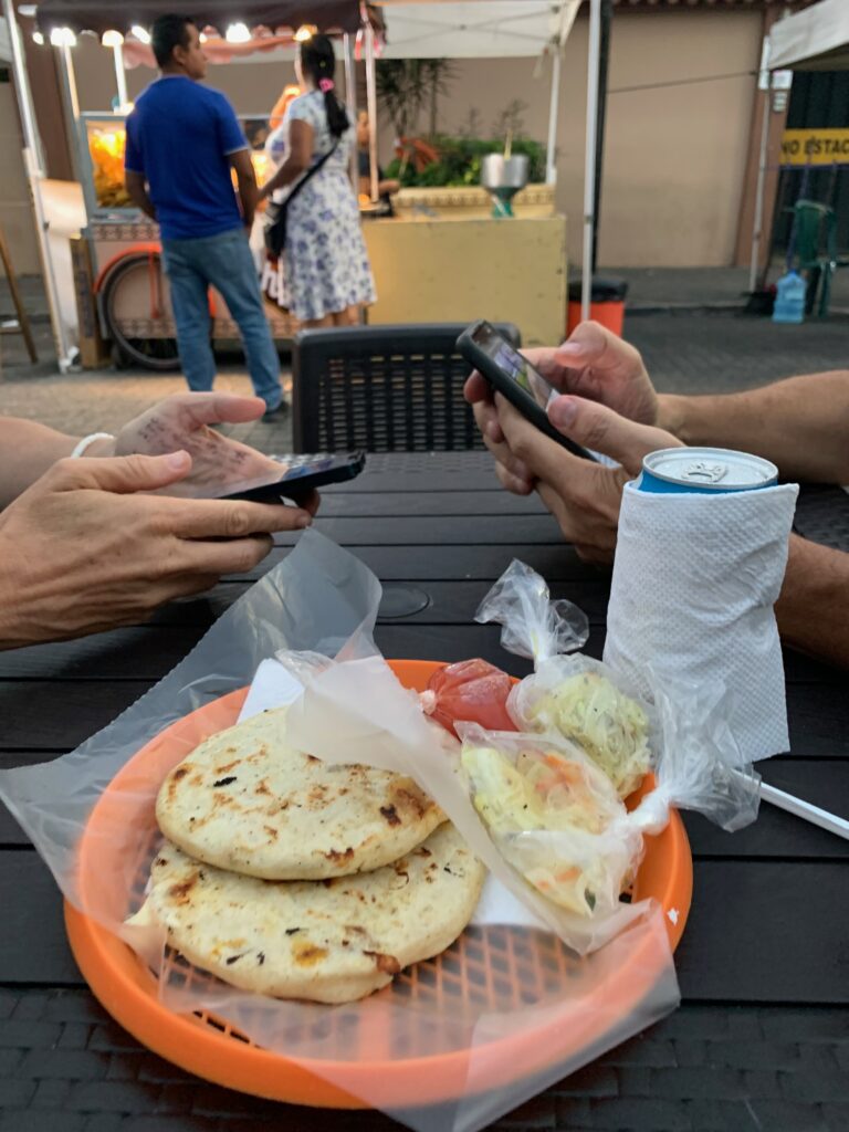 a group of people sitting at a table with food on it