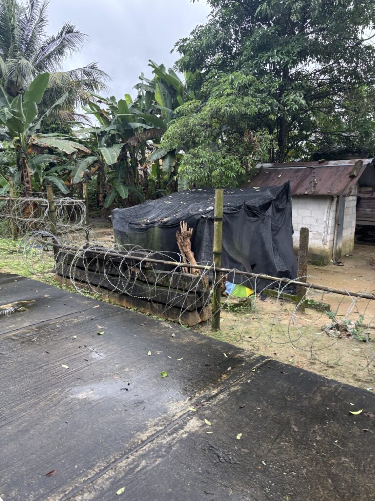 a fenced in area with barbed wire and a building