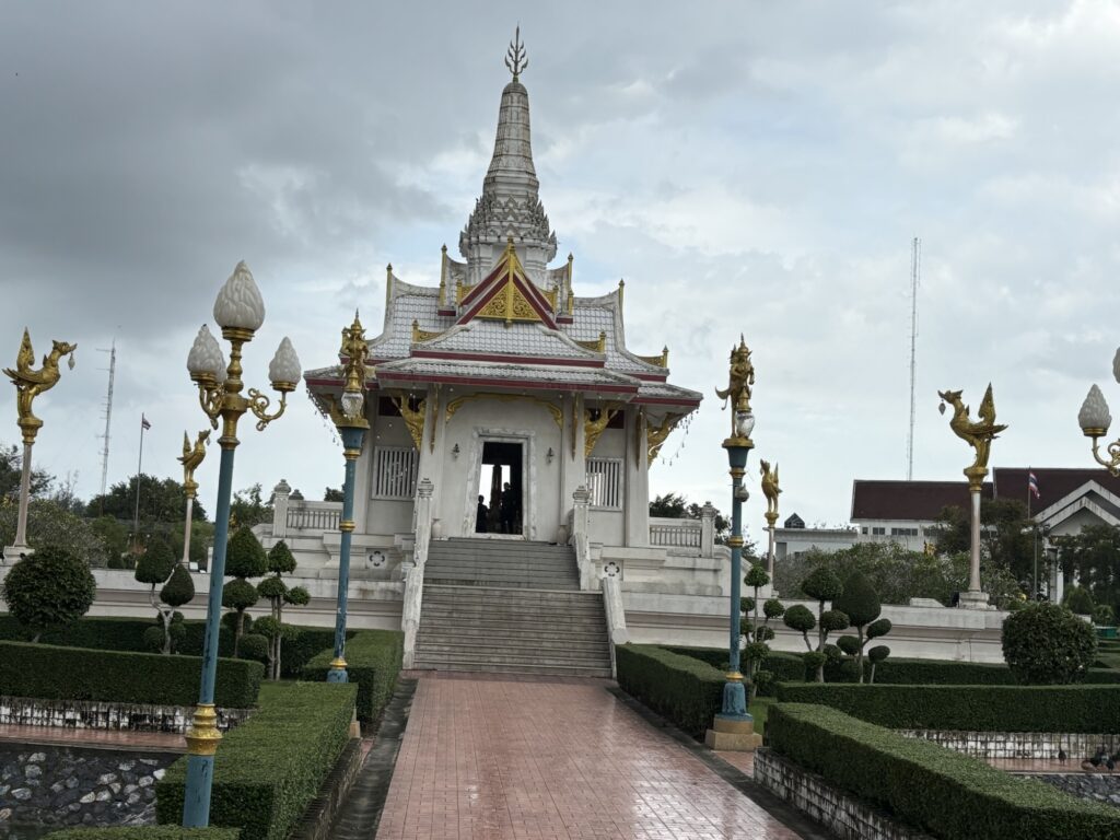 a white building with a tower and stairs leading to a garden