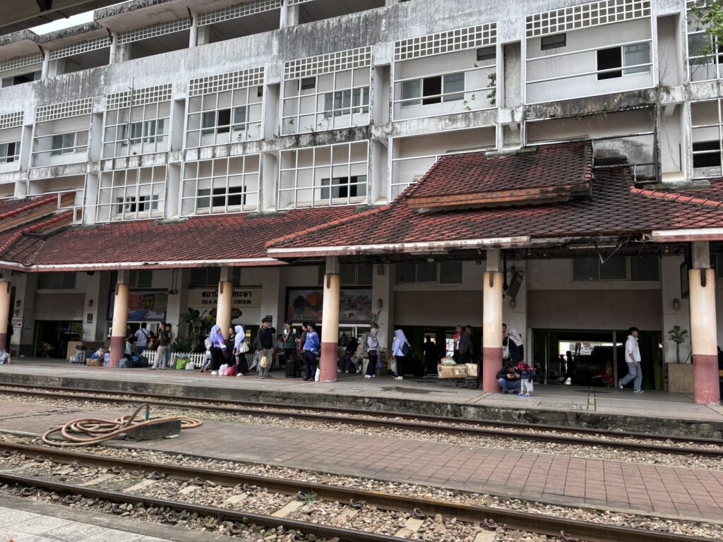 a group of people standing outside of a train station