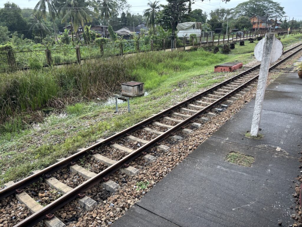 a train tracks next to a sidewalk