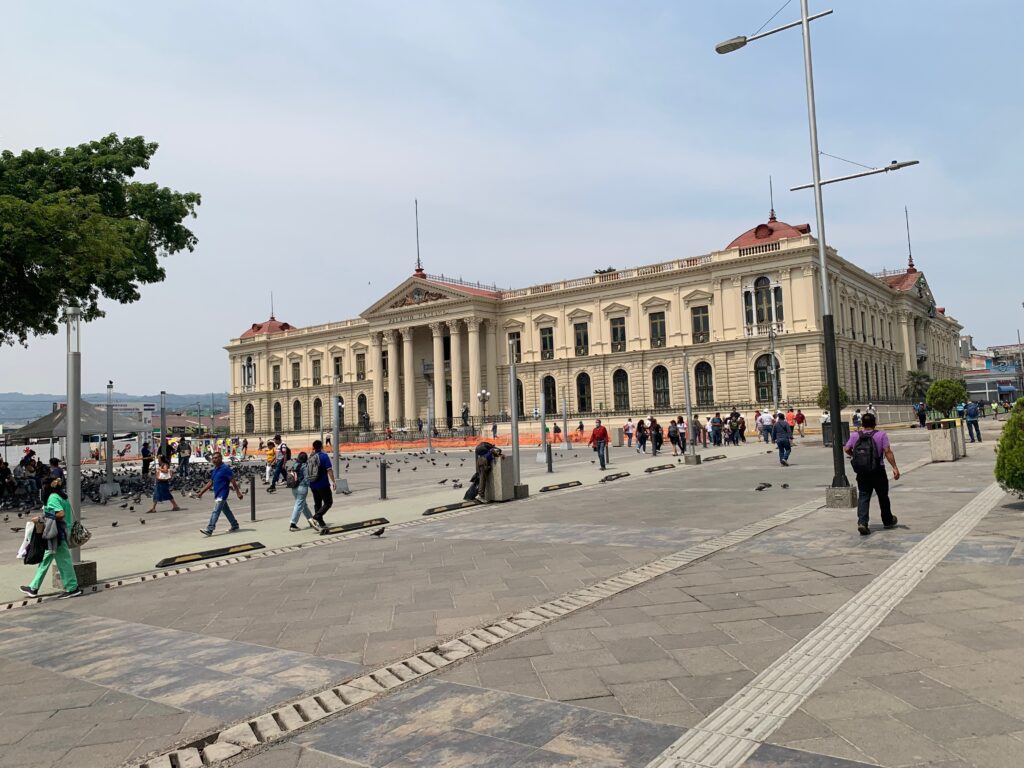 a large building with columns and people walking around