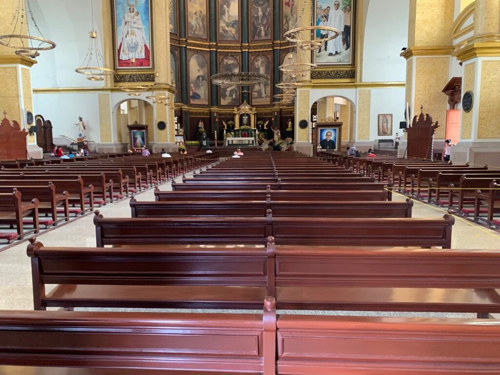 a church with benches and a large wall