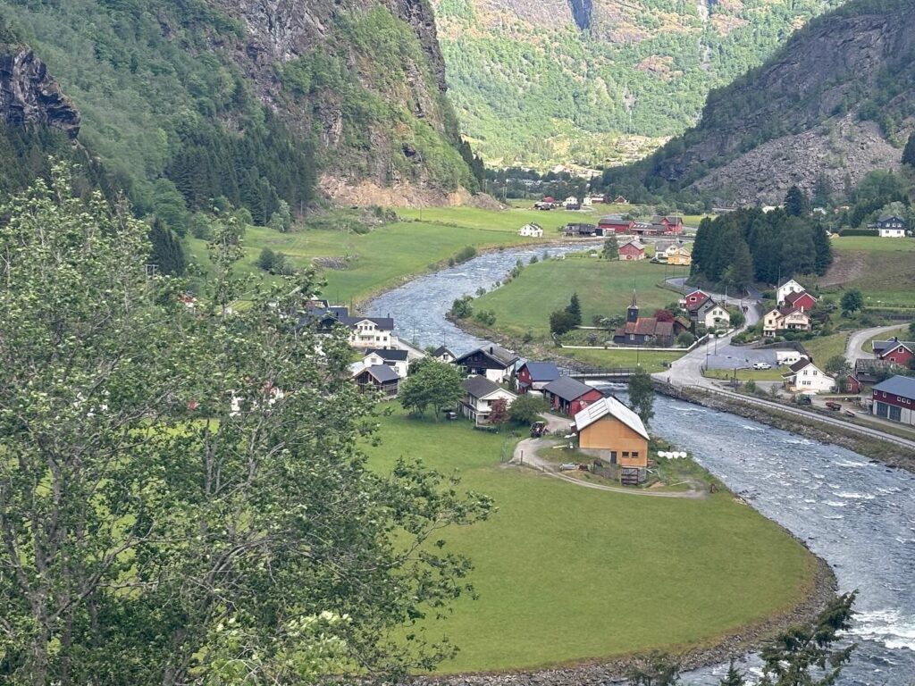 a river running through a valley with houses and trees