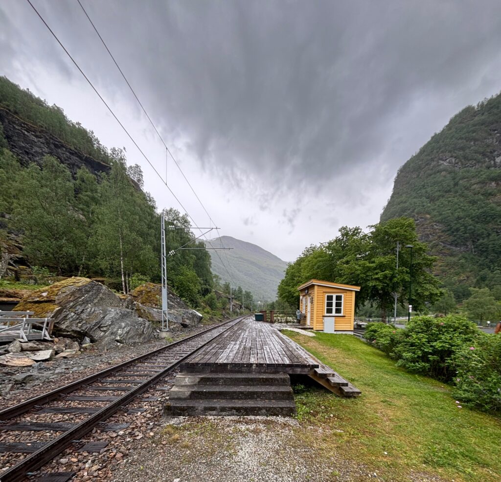 train tracks next to a small building