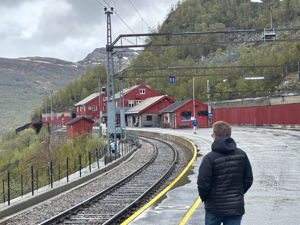 a man standing on a train track next to a train station
