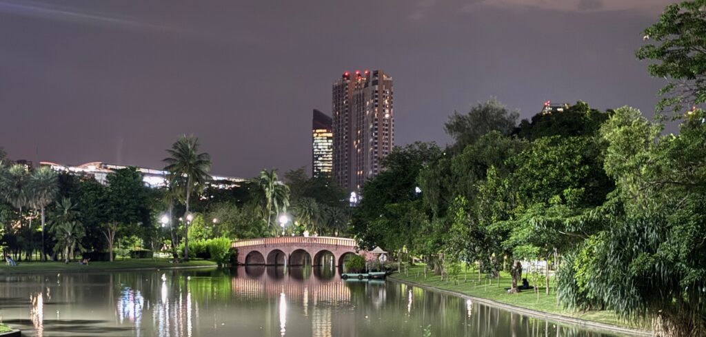 a bridge over a body of water with trees and buildings in the background