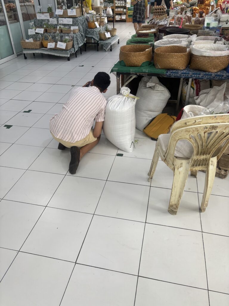 a man kneeling on the floor next to bags of goods