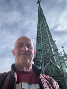 a man taking a selfie in front of a tall building